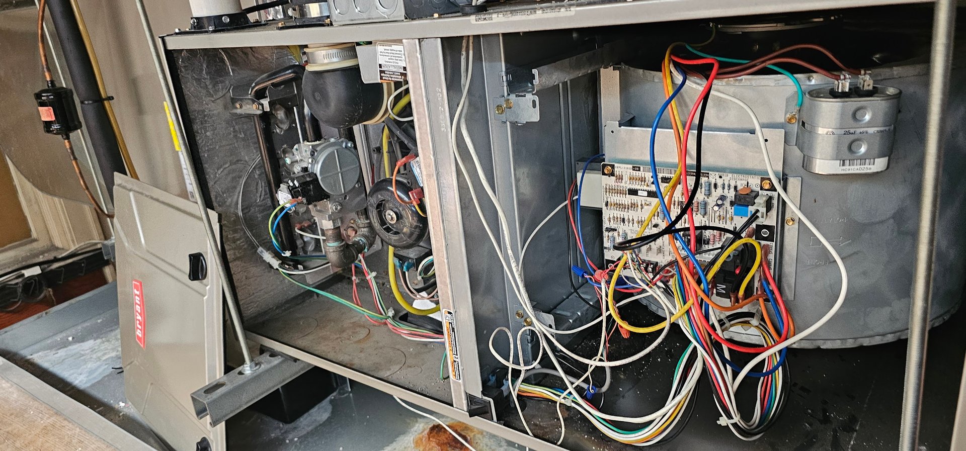 Mechanical Temp technician diagnosing a Bryant furnace - panels open showing controls and wiring